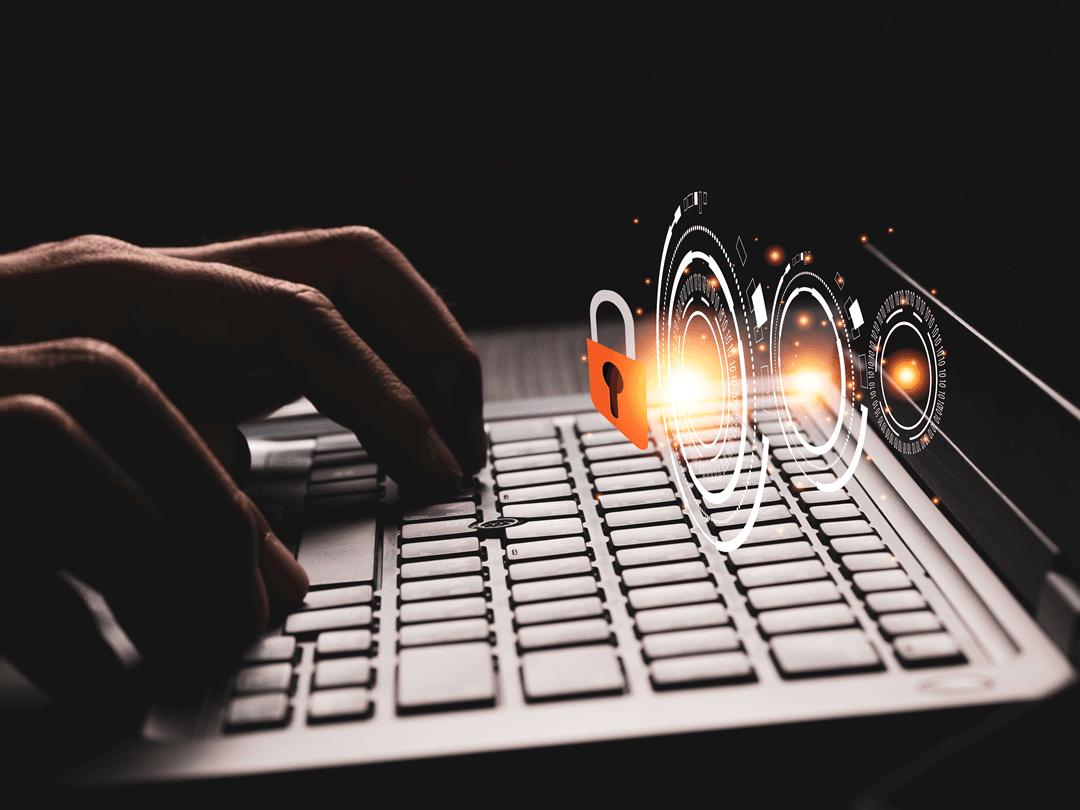 Ciemne ujęcie dłoni piszących na klawiaturze laptopa, symbolizujące cyberbezpieczeństwo i ochronę danych. Nałożona grafika przedstawia cyfrowe elementy interfejsu, w tym świecący zamek i futurystyczne okręgi, sugerujące zabezpieczenia i ochronę prywatności w sieci.