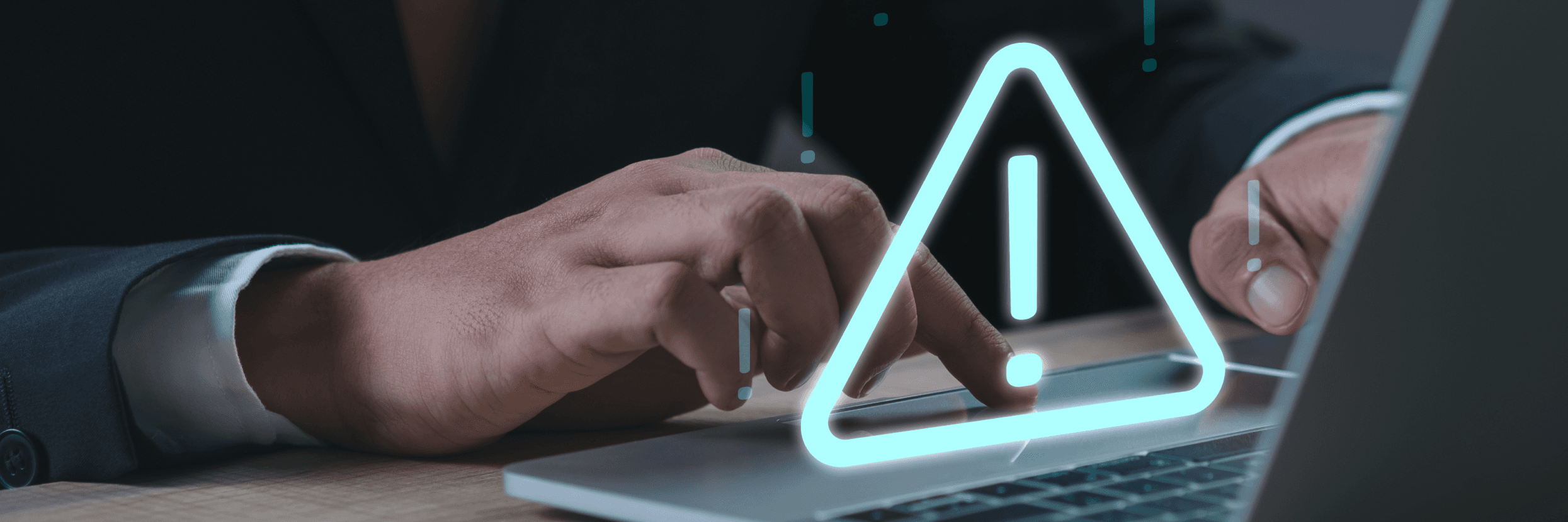 Dłonie piszące na laptopie na nich świetlisty trójkąt z wykrzyknikiem w środku.
