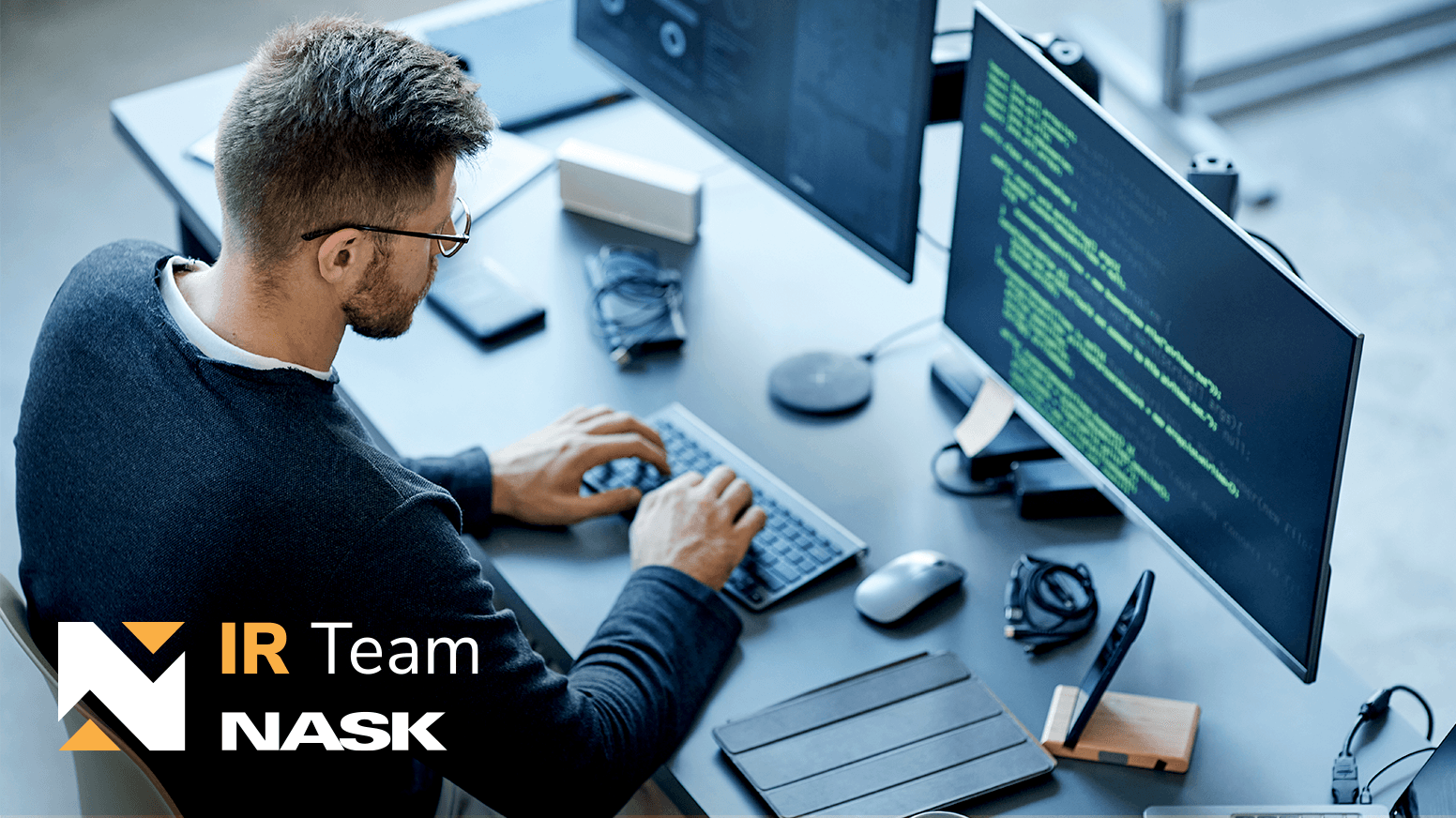 Mężczyzna siedzący przy komputerze i kodujący