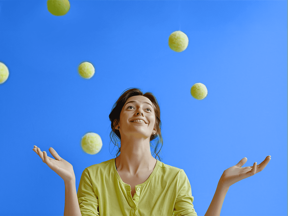 Kobieta podrzucająca kilka żółtych piłeczek